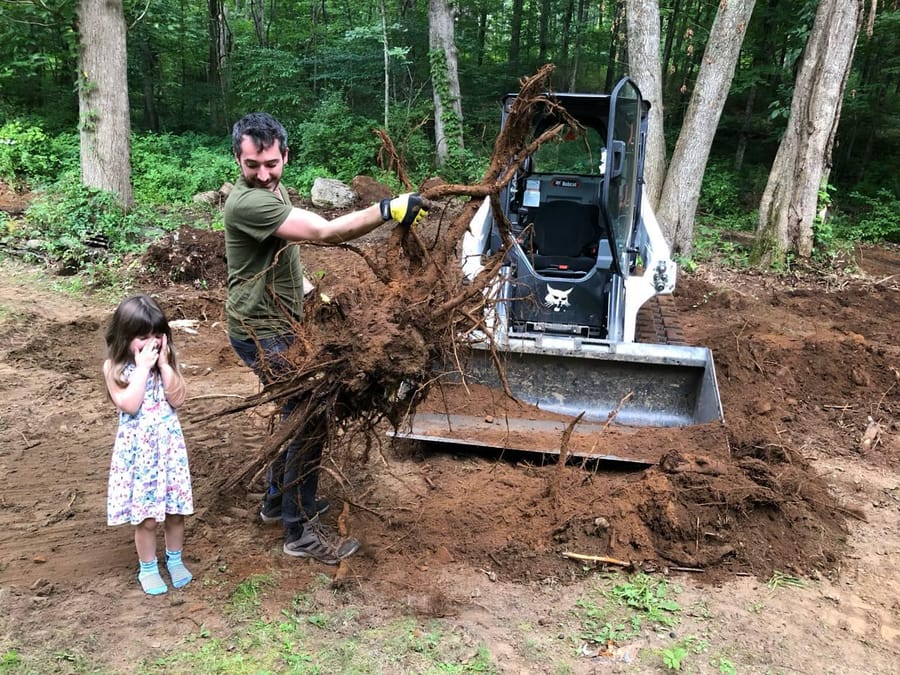 The founder and his daughter clearing land with a skid-steer